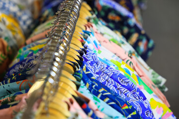 Colorful shirts on hangers in a clothing store, Summer concept.