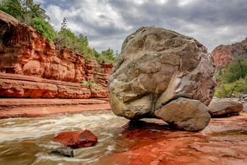 A giant gray boulder sits at the edge of Oak Creek at Slide Rock State Park near Sedona Arizona - 763483943