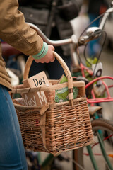 A close-up of a basket holds homemade May Day packages with "May Day" written on them