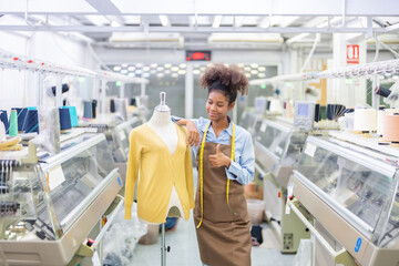 American female designer is a seamstress in the middle of a fabric factory, company business,...