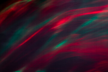 Defocused abstract red and green background of speed camera movement over glowing lights. A pattern of flashes of light similar to the northern lights