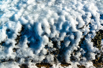 Smooth blocks of melting ice glisten in the sun, ice near the Black Sea, Odessa
