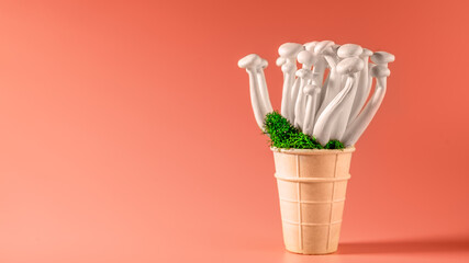 shimeji mushrooms with green moss in an ice cream cone, on bright, colorful, pink background