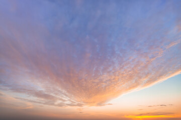Fototapeta premium A beautiful sky tinted by the sun leaving vibrant shades of gold, pink, blue and multicolored. Clouds in the twilight evening and morning sky. Cloudy sky background in the evening and during the day.