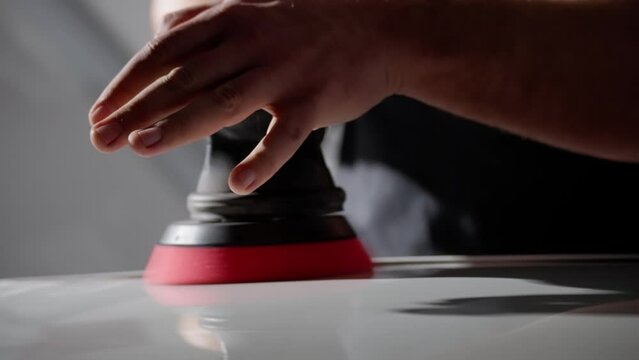 Close-up of a hand pressing an air hockey pusher on a gaming table with focus on the interaction