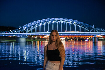 Portrait of a Young Woman with the Illuminated Jozef Pilsudski Bridge, Krakow - obrazy, fototapety, plakaty