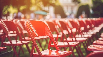 Line of folding chairs arranged outdoors, prepared for an event or activity in the open air, ready for participants.