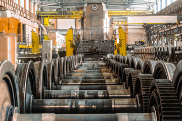 Row of steel wagon train wheels in front of the locomotive. Repair depot. Wheels of train in...