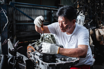 A man is working on a car engine in a garage