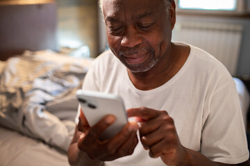 Senior man using smartphone at home