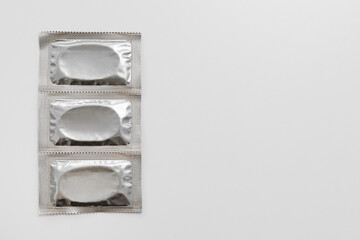 Close up of three silver packages condoms with copyspace