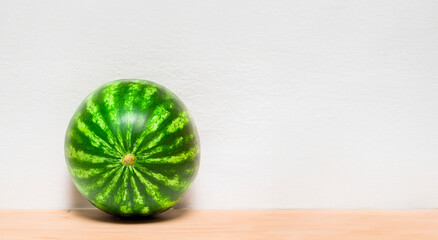 close-up view of a whole, ripe watermelon with green rind and stripes on a white background - 763504736
