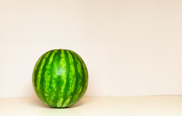 close-up view of a whole, ripe watermelon with green rind and stripes on a white background - 763504748