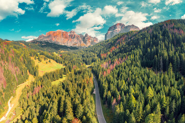 Panoramic aerial view of mountain valley with highway and rocks on a sunny day. Sella Towers Rocks against the sky. Dolomites Road toward the Sella Pass. The dolomites in South Tyrol, Italy - 763506725
