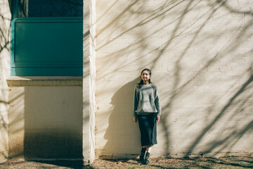 a woman standing on a modern building in the sunlight