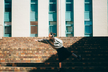 a woman standing on a modern building in the sunlight