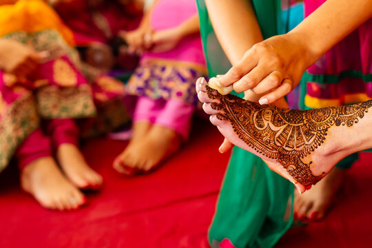 Henna tattoo artist prepares Indian bridal feet at Mehndi ceremony