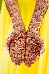 Open palm hands of Indian bride at Mehndi ceremony with henna tattoo design