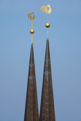 weathercocks on the tops of a church with twin towers