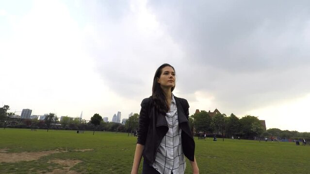Young woman relaxing and walking at park on a cloudy day in London