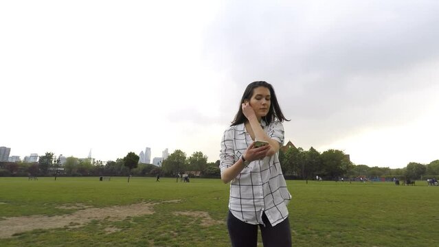 Young woman relaxing and walking at park on a cloudy day in London