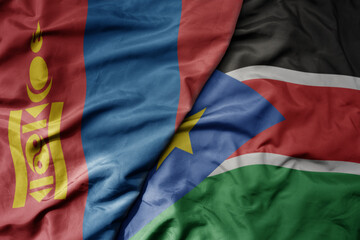 big waving national colorful flag of south sudan and national flag of mongolia.