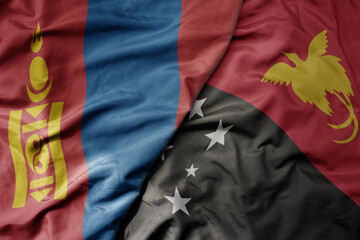 big waving national colorful flag of Papua New Guinea and national flag of mongolia.