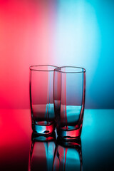 Drinking transparent glasses on a colored background with reflection. - 763518399