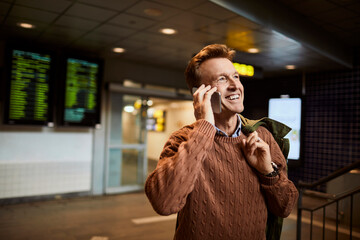 Mature man talking on the phone while waiting at the train station