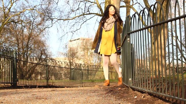 Happy asian young woman enjoying a sunny day at park in London