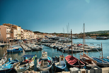 yacht harbor of beautiful Saint Tropez along the coastline of the mediterranean sea of the french riviera on a sunny day. - obrazy, fototapety, plakaty