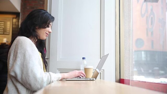 Young woman using laptop computer in a cafe