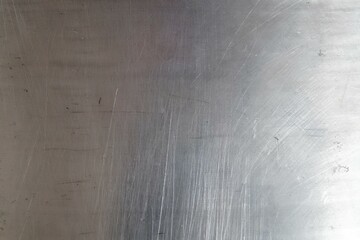 A silver surface with a lot of scratches and marks