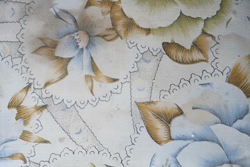 A floral patterned wallpaper with a lace border
