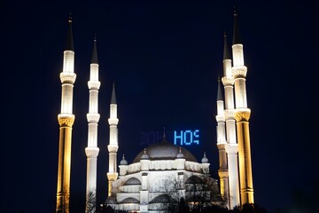 A large white mosque with blue letters