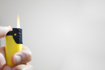 A person is holding a lighter with a yellow and black handle