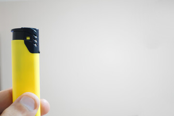A person is holding a yellow lighter