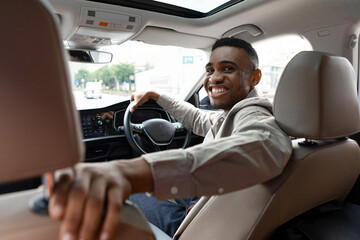 Joyful African American Man Smiling Sitting In Automobile Looking Back At Camera