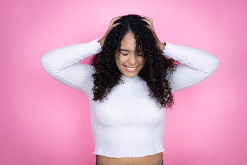 African american woman wearing casual sweater over pink background suffering from headache...