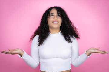 African american woman wearing casual sweater over pink background clueless and confused expression...