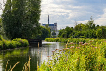 View of the Cathedral of Amiens from the banks of the River Somme in the famous Hortillonnages of Amiens in Picardy, France - obrazy, fototapety, plakaty