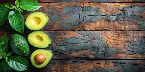 Fotobehang Avocados and Leaves on a Wooden Table © yganko