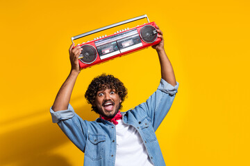 Photo portrait of nice young male hold excited boombox hip hop wear trendy denim outfit red scarf isolated on yellow color background