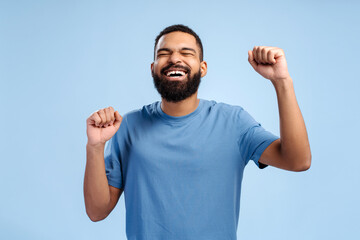 Attractive overjoyed bearded african american man, winner win money, gesturing, with closed eyes