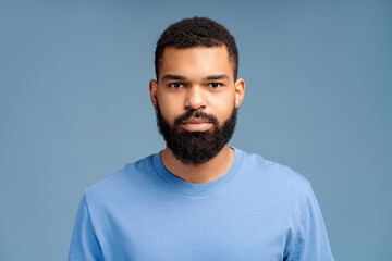 Portrait of attractive, African American bearded young man wearing casual blue t shirt
