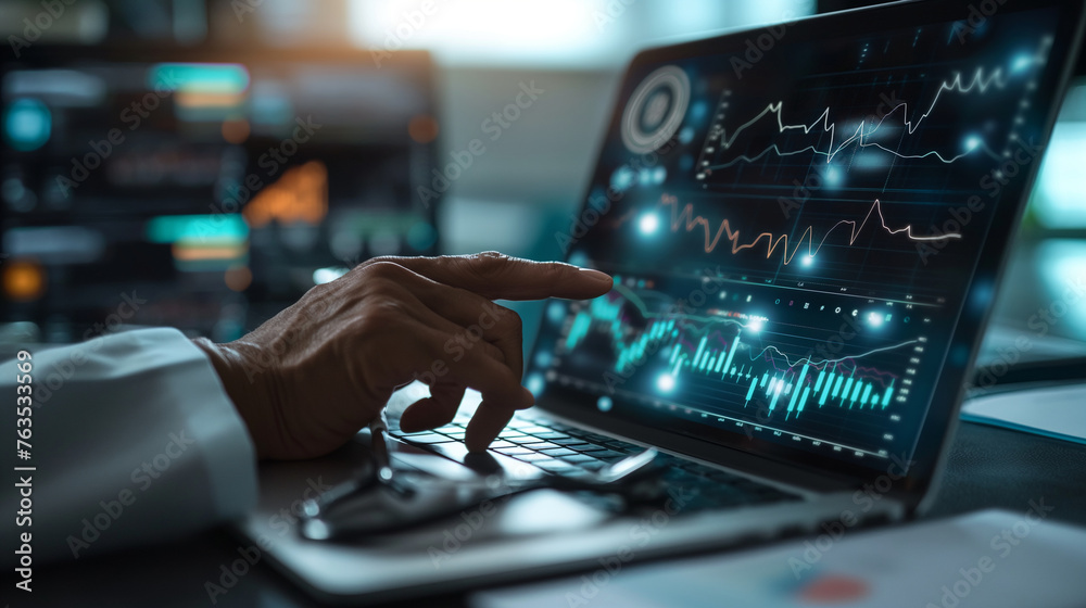 Wall mural close-up of a businessman's hands pointing at a healthcare business graph on a laptop screen, with s