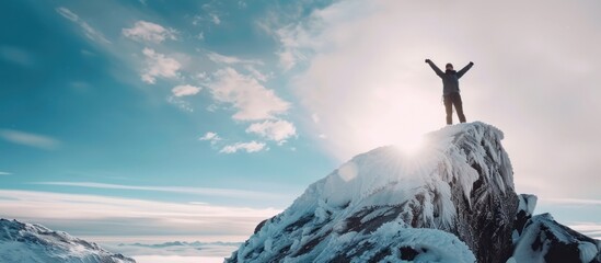 man hiker standing at top of a snowy mountain in winter.