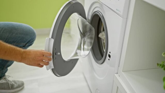 A man doing laundry in a modern home interior with a focus on the washing machine and his actions
