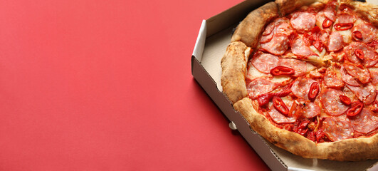 Delicious pepperoni pizza in cardboard box on red background with space for text