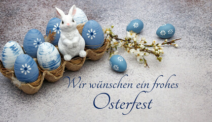 Osterhase sitzt auf Ostereiern mit der Beschriftung wir wünschen ein frohes Osterfest. - obrazy, fototapety, plakaty